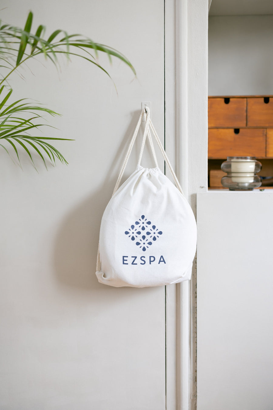 Le sac de transport en coton Ezspa avec le logo, suspendu dans une chambre