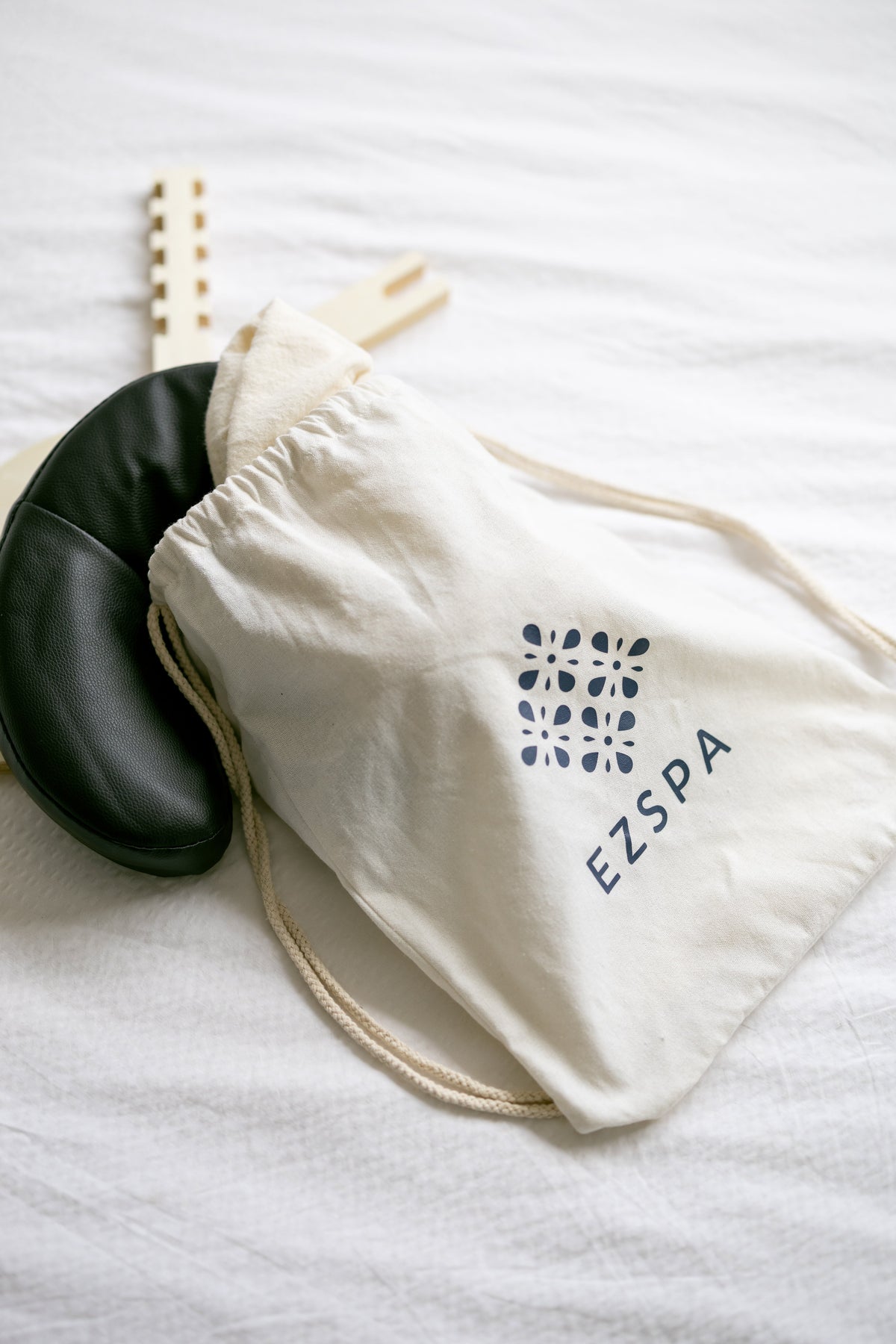 Le sac de transport avec le coussin de tête noir et le cadre en bois à côté