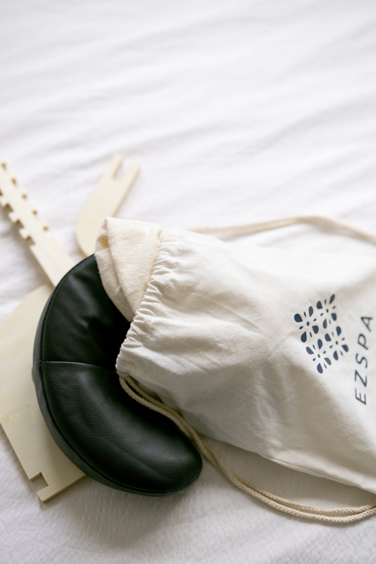 Le sac de transport avec le coussin de tête noir et le cadre sur un lit