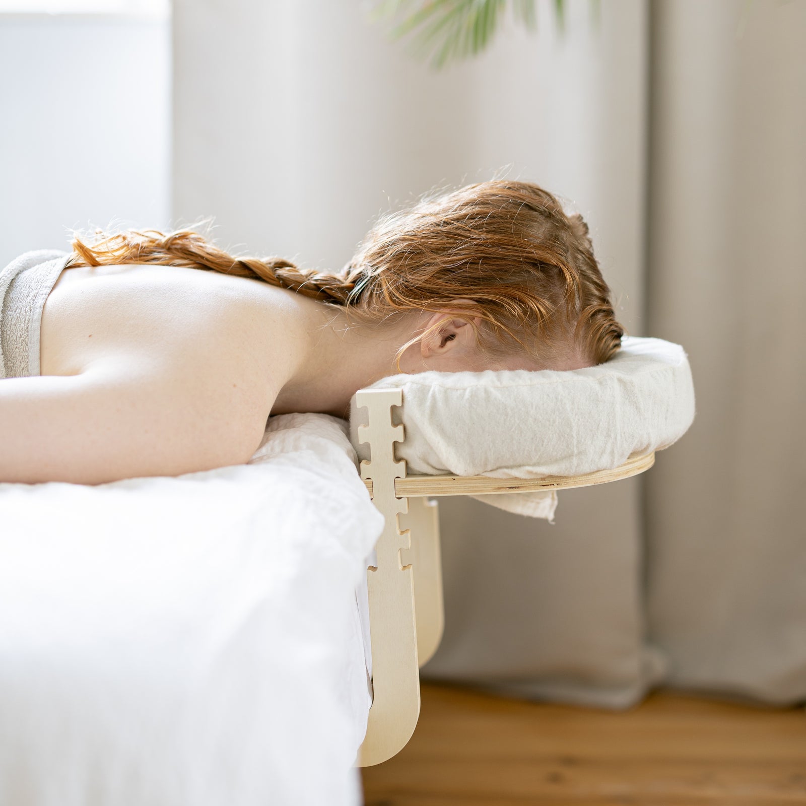 Une personne allongée détendue sur un lit, la tête dans l'appui-tête Ezspa